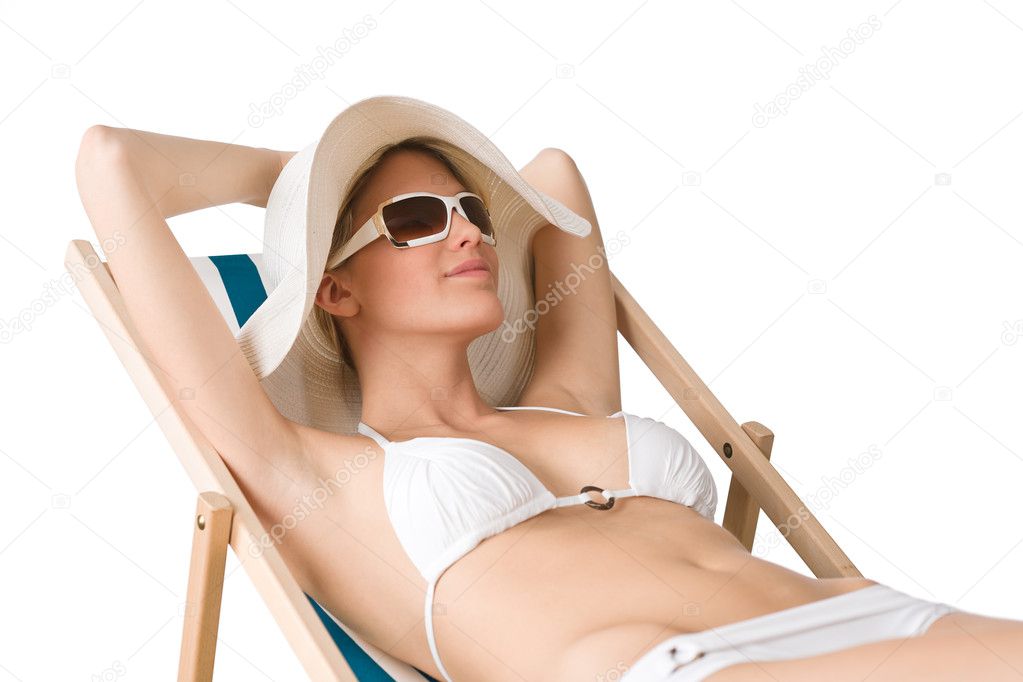Beach - woman in bikini with hat sunbathing