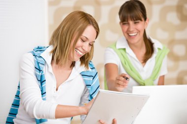 Student at home - two happy woman with laptop and book study clipart