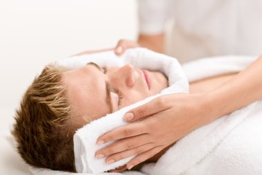 Male cosmetics - luxury spa treatment receiving facial massage clipart