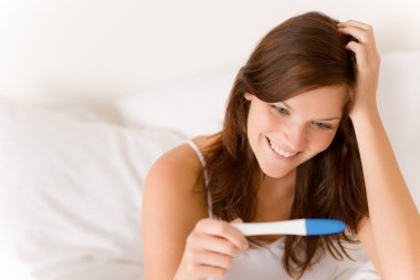 Pregnancy test - happy surprised woman, positive result clipart