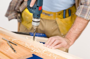 Home improvement - handyman drilling wood in workshop