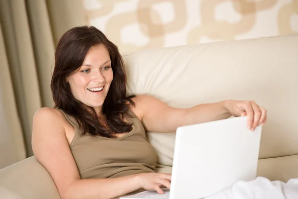 Dinlenme Odasındaki Kanepede Dizüstü Bilgisayarıyla Oturan Gülümseyen Kadın — Stok fotoğraf