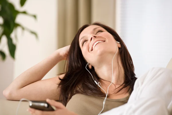 Kobieta Trzyma Odtwarzacz Muzyki Słucha Smyczą Leżenie Kanapie Domu — Zdjęcie stockowe