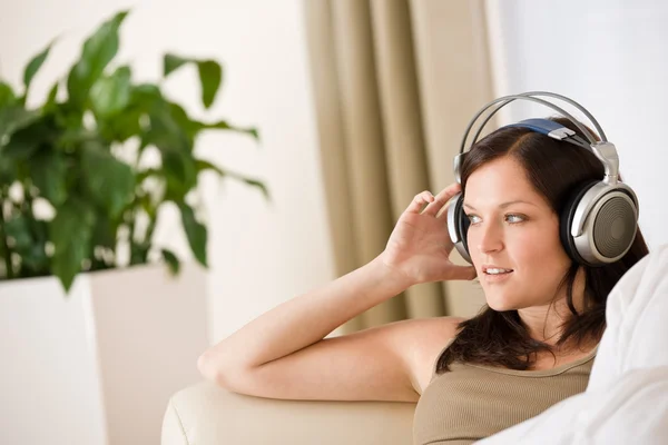女人用耳机听听音乐在休息室 背景中的植物 — 图库照片