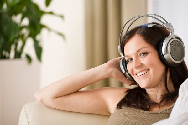 Kvinna med hörlurar lyssna på musik i loungen — Stockfoto