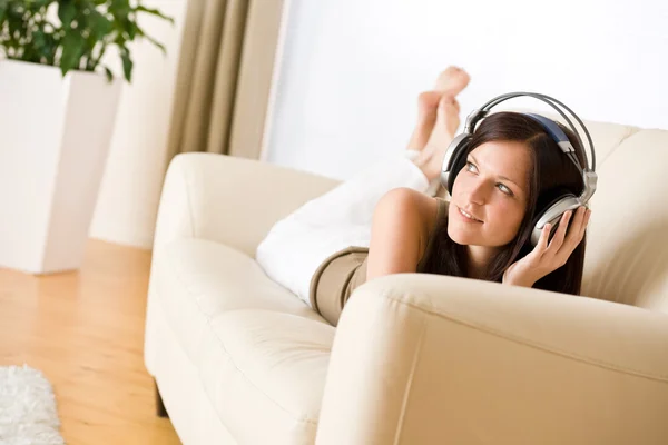 Γυναίκα Ακουστικά Ακούτε Μουσική Στο Lounge Φυτό Στο Παρασκήνιο — Φωτογραφία Αρχείου