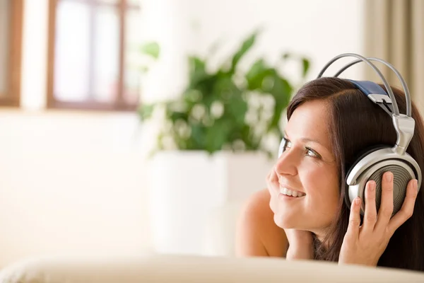 Vrouw met hoofdtelefoon luisteren naar muziek in lounge — Stockfoto