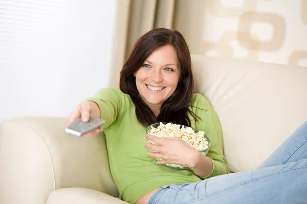 Mulher assistindo televisão com pipocas na sala de estar — Fotografia de Stock