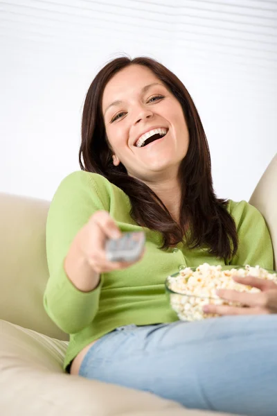Frau zeigt mit Fernbedienung auf Fernseher — Stockfoto