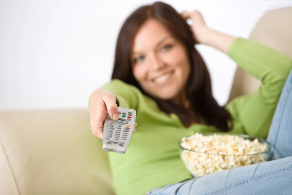 Kvinnan tittar på TV med popcorn i vardagsrum — Stockfoto
