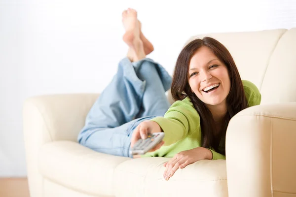 Mulher alegre mudar de televisão na sala de estar — Fotografia de Stock