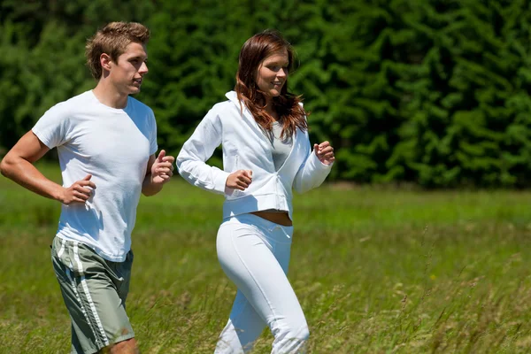晴れた日に屋外でジョギング若いカップル春の自然 — ストック写真