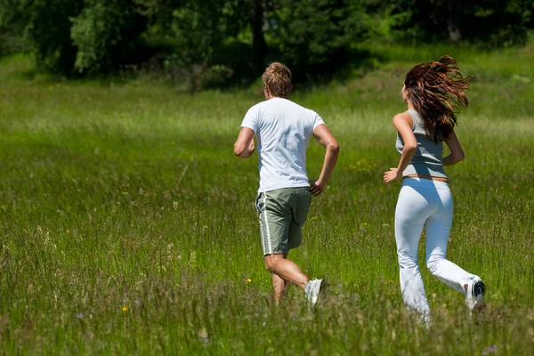 Молода пара біжить на відкритому повітрі у весняній природі — стокове фото