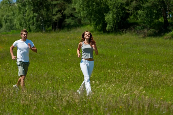 年轻的夫妇在户外慢跑弹簧性质上阳光灿烂的日子 — 图库照片