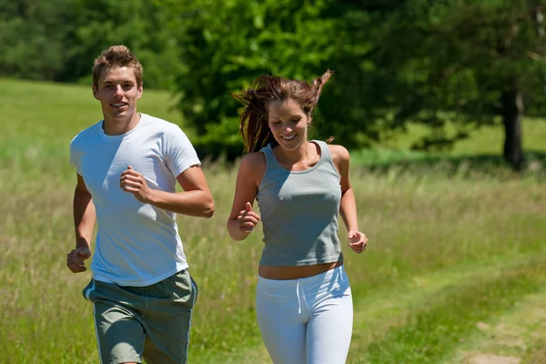 Jeune couple jogging en plein air dans la nature printanière — Photo
