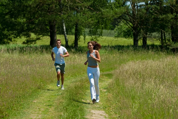 年轻的夫妇在户外慢跑弹簧性质上阳光灿烂的日子 — 图库照片