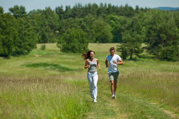 Jovem casal correndo ao ar livre na natureza primavera — Fotografia de Stock