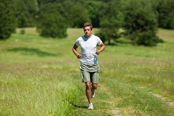 Jeune Homme Avec Casque Jogging Dans Une Prairie Peu Profonde — Photo
