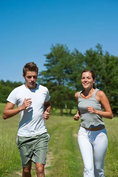 Young couple jogging outdoors in spring nature — Stock Photo, Image