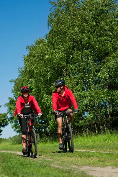 Jovem casal com bicicleta montesa na natureza primavera — Fotografia de Stock