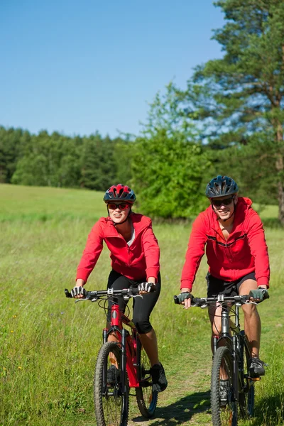 Молодая пара с горным велосипедом в весенней природе — стоковое фото