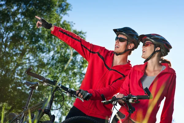晴れた日に自転車に乗ること春の自然の Mountine バイクと若いカップル — ストック写真