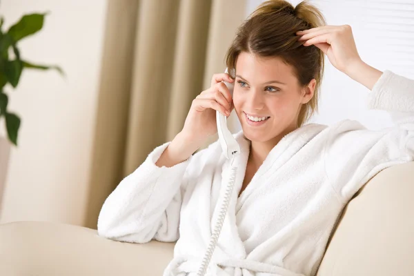 Femme heureuse en peignoir blanc avec téléphone maison — Photo