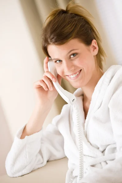 Mulher feliz em roupão branco com telefone — Fotografia de Stock
