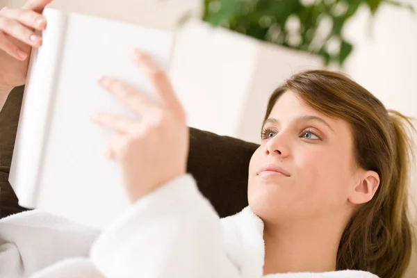 Young woman read book lying down on sofa — Stock Photo, Image