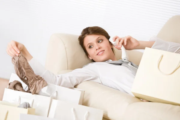 Joven mujer de negocios con bolsa de compras en sofá — Foto de Stock