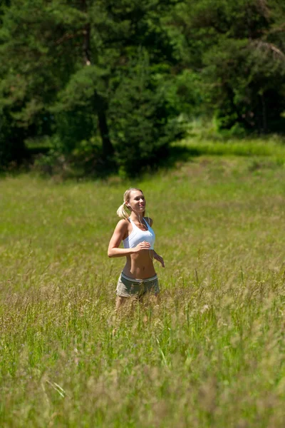 Jovem mulher correndo em um prado — Fotografia de Stock