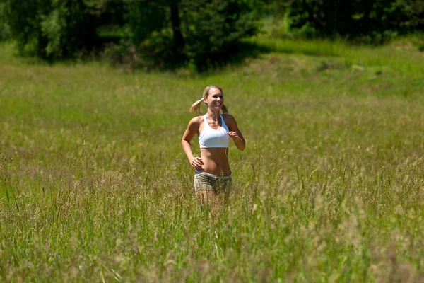 Giovane donna che corre in un prato — Foto Stock