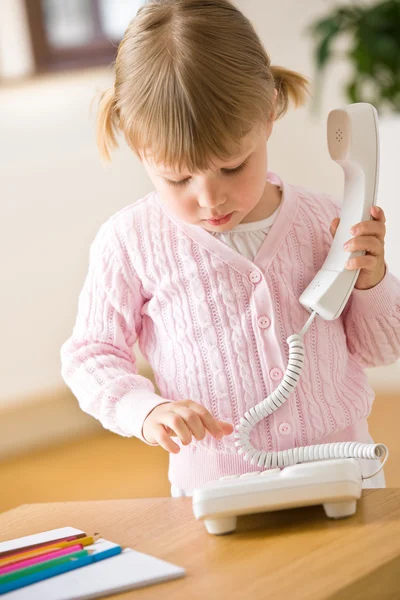 Κοριτσάκι κλήση αριθμού τηλεφώνου στο σαλόνι — Φωτογραφία Αρχείου