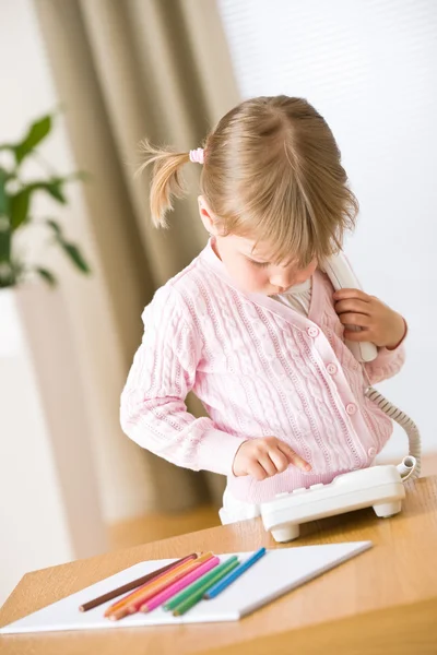 Little girl dial number on phone in lounge — Stock Photo, Image