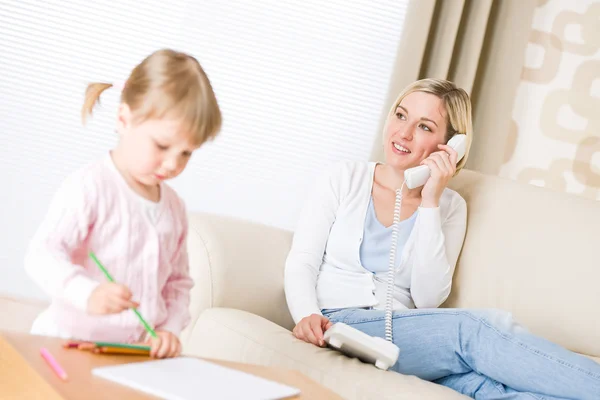 ラウンジでは 色鉛筆で描く少女電話通話と母親 — ストック写真