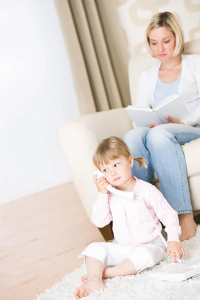 Matka a dítě - na telefonu v obývacím pokoji — Stock fotografie