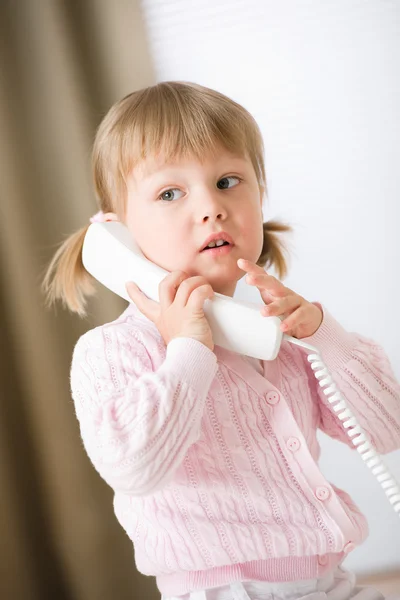 Liten flicka håller telefon mottagare ringer — Stockfoto