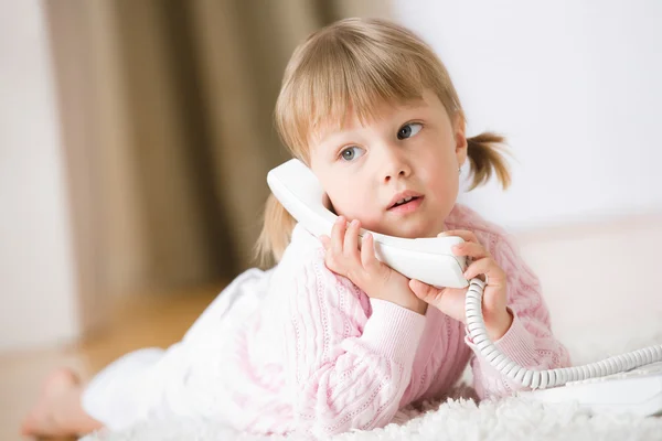 Petite Fille Couchée Sur Tapis Avec Téléphone Tenant Récepteur Téléphonique — Photo