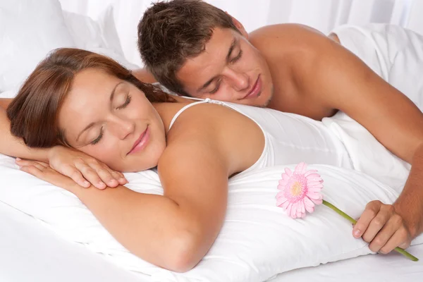 Молодая пара лежит в постели — стоковое фото