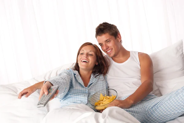 Ung man och kvinna liggande i vit säng — Stockfoto