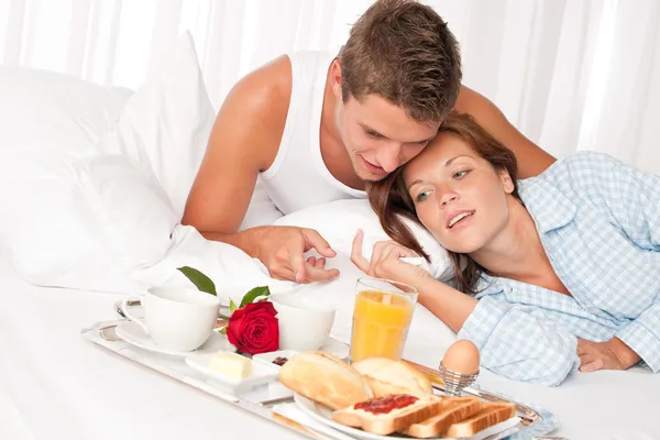 Boldog férfi és nő-tekintettel reggeli az ágyban együtt — Stock Fotó