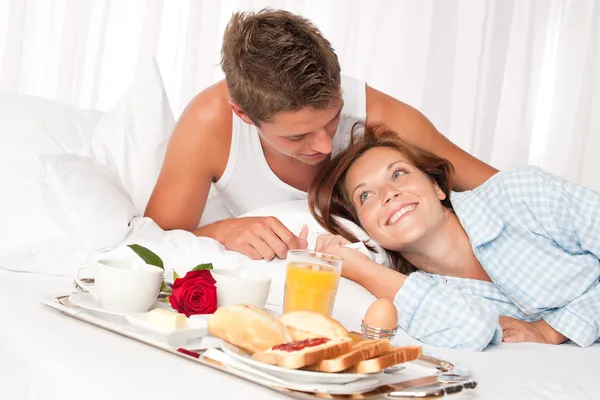 Молодая улыбающаяся пара с роскошным завтраком — стоковое фото