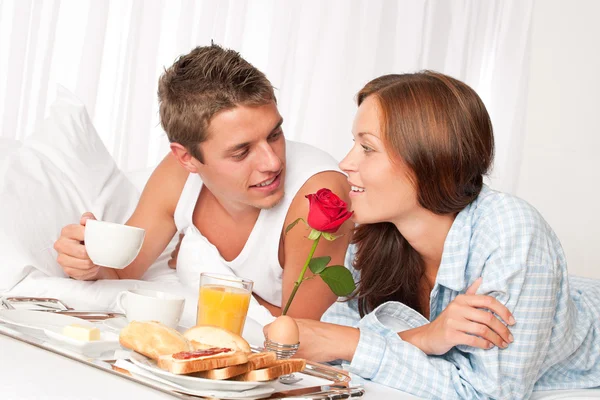Homem e mulher felizes tomando café da manhã na cama juntos — Fotografia de Stock