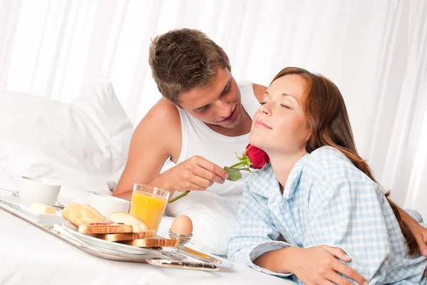 Heureux homme et femme prenant le petit déjeuner au lit ensemble — Photo