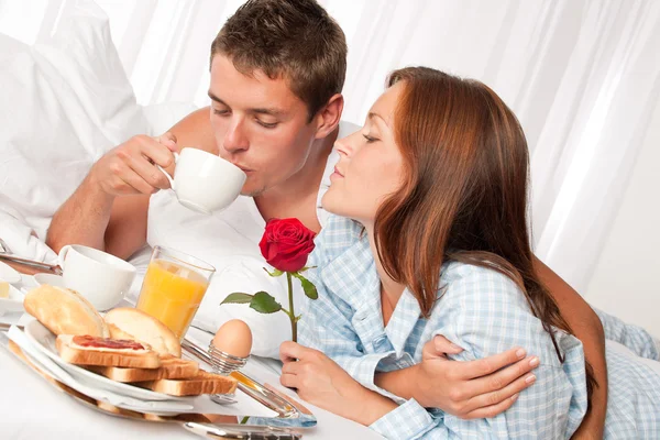 Šťastný muž a žena spolu s snídaně v posteli — Stock fotografie