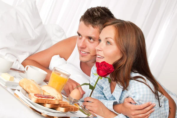 幸福的男人和女人在一起躺在床上吃豪华酒店早餐 — 图库照片