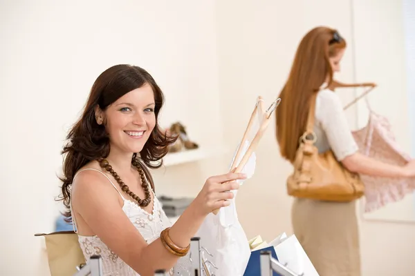Compras de moda - Duas mulheres felizes escolhem roupas de venda — Fotografia de Stock