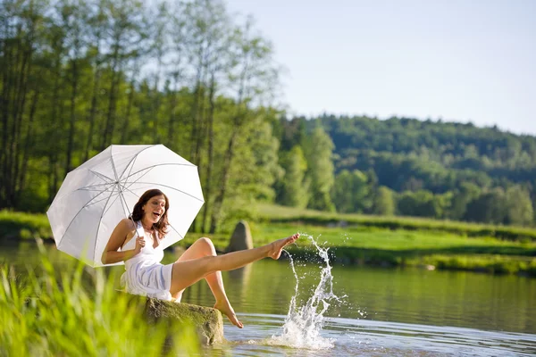 Su sıçramasına göl kenarında oturan mutlu romantik kadın — Stok fotoğraf