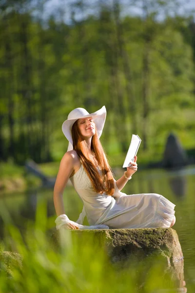 Long red hair romantic woman relax by lake with book — Stock Photo, Image