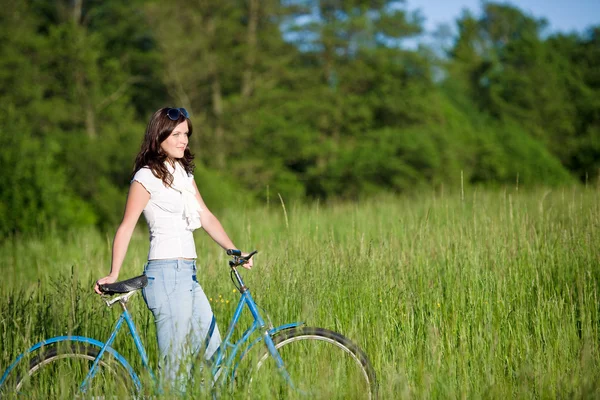 Woman with old-fashioned bike in summer meadow — Stock Photo, Image